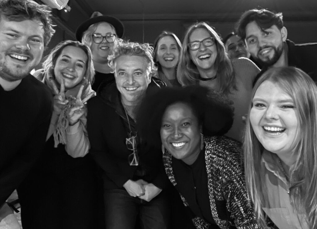 Ten smiling people having a lovely time - all members of the arts company Unlimited Theatre